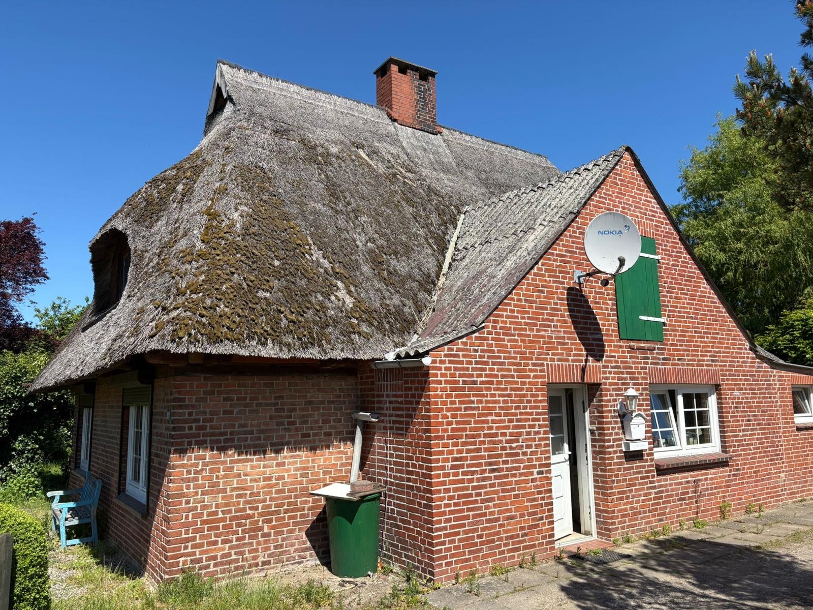 Giebelseite des Hauses mit Eingangstür und grünem Fensterladen